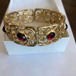 2028 Gold Tone bracelet with red stones.